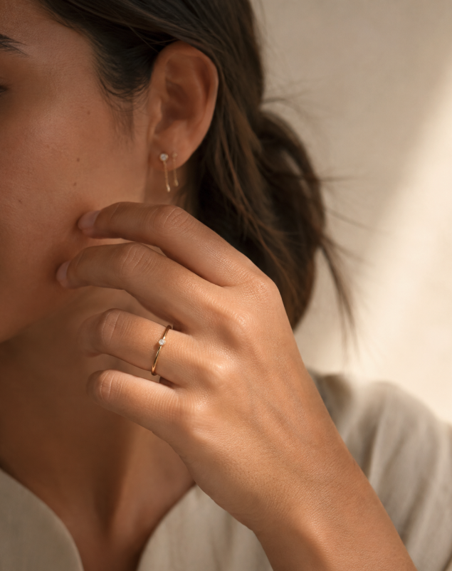 Mulher com anel fino em ouro e brinco discreto